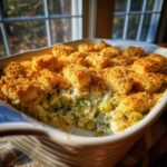Close-up of a creamy, bubbling broccoli casserole with a thick, golden-brown breadcrumb topping.