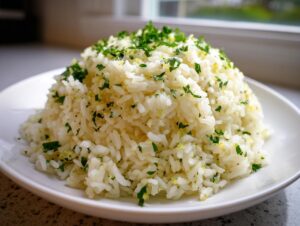 A mound of fluffy garlic butter rice seasoned with minced garlic and topped generously with fresh chopped parsley.