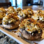 Close-up of freshly baked stuffed mushrooms featuring a golden, crispy breadcrumb topping.