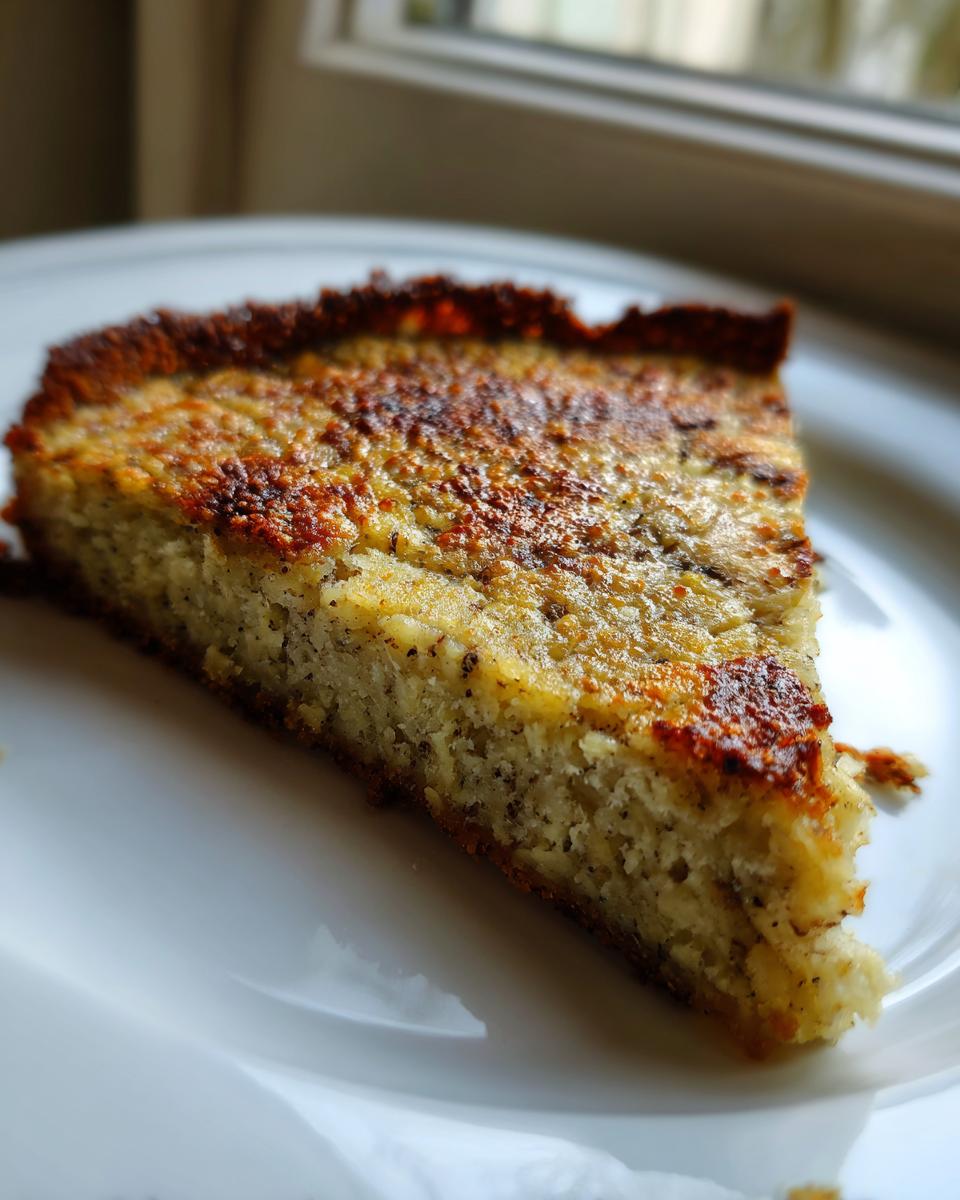 A thick, golden-brown slice of baked keto pizza crust resting on a white plate.