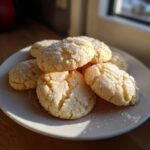 A stack of freshly baked, crackled butter cookie treats generously coated in sparkling sugar crystals.