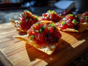 Close-up of fresh tuna tartare served on crispy wonton cups, glistening under bright light.