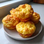 A stack of five fluffy, golden-brown homemade egg bites served on a small white plate.
