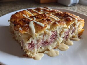 A close-up of a hearty slice of homemade Reuben bake with melted cheese and a drizzle of sauce.