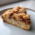 Close-up of a soft slice of coffee cake cookies featuring a thick cinnamon swirl and crumbly streusel topping.