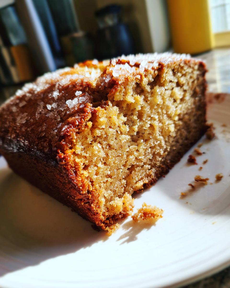Close-up of a slice of moist zucchini banana bread topped with coarse sugar crystals.