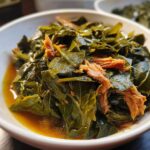 Close-up of tender collard greens simmered in savory pot liquor with shredded smoked meat.