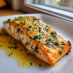 A perfectly cooked fillet from the baked salmon recipe, topped with a glistening garlic and herb sauce.