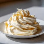 A beautiful swirl of whipped honey butter recipe mixture served in a small white bowl.