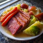 A plate featuring tender sliced corned beef and cabbage, carrots, and red potatoes.