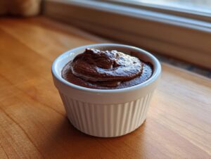 A single serving of rich, dark chocolate mousse made with cottage cheese in a white fluted ramekin.