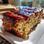 A moist slice of stove top stuffing meatloaf topped with a thick, glossy brown glaze.