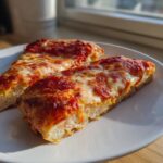 Two slices of pizza featuring a thick, fluffy cottage cheese pizza crust topped with bright red sauce and melted mozzarella cheese.