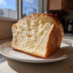 Close-up of a thick slice of light, fluffy carnivore bread showing its soft, airy crumb structure.