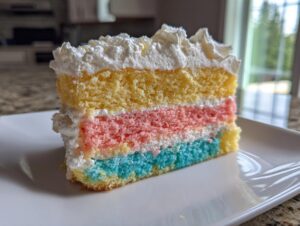 A colorful slice of three-layer cake with yellow, pink, and blue sponge, topped with whipped cream, perfect for a cake picnic.