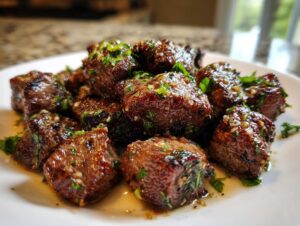 Close-up of juicy Garlic Butter Steak Bites, glistening with sauce and topped with fresh parsley.
